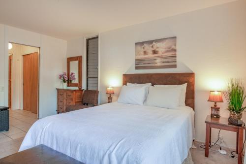una camera da letto con un grande letto con lenzuola bianche di Kona Bali Kai #161 a Kailua-Kona