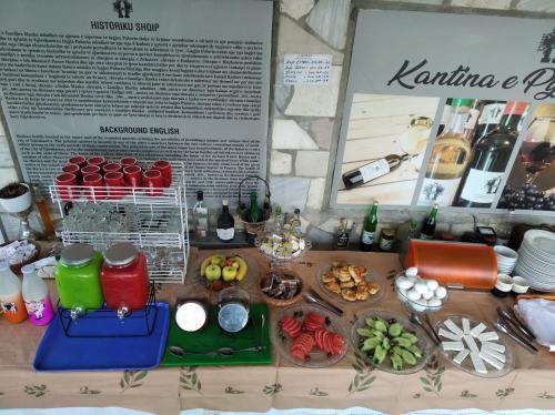 a table with a bunch of food and bottles of wine at Guest House Bake in Gjirokastër