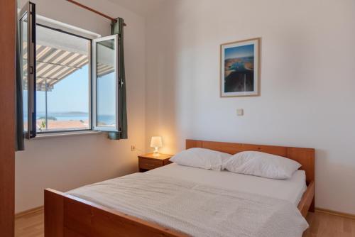 1 dormitorio con cama y ventana grande en Rasin Apartments, en Pakoštane