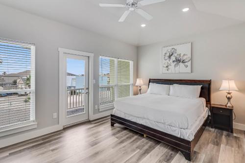 ein Schlafzimmer mit einem Bett und zwei Fenstern in der Unterkunft Vacation's Callin' on Ports O Call in Padre Island