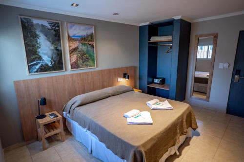 ヴィラ・カルロス・パスにあるNuevo Centro Hotel Villa Carlos Pazのベッドルーム1室(ベッド1台、タオル2枚付)