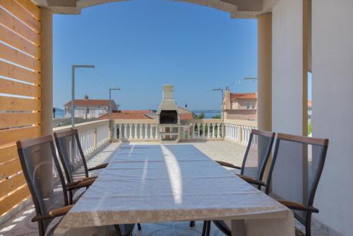 stół i krzesła na balkonie z widokiem w obiekcie Rasin Apartments w Pakoštane