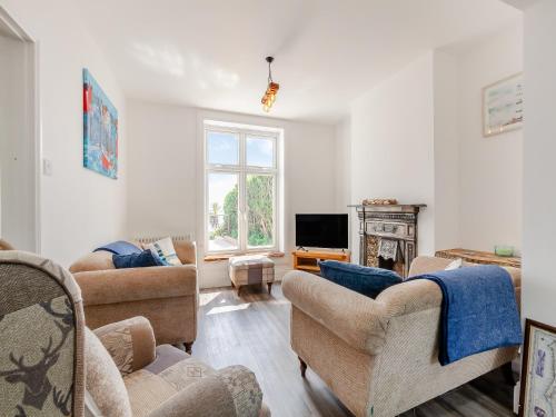 a living room with two couches and a tv at Happy House in Bevendean