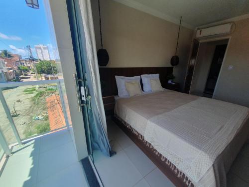 Schlafzimmer mit einem Bett und einer Glasschiebetür in der Unterkunft Casa Praia São Jose Maragogi 4 in São José da Coroa Grande
