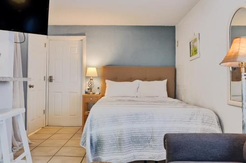 Un dormitorio con una cama y una mesa con una lámpara. en Shortboard, en Holmes Beach