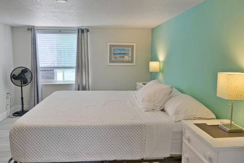 - une chambre avec un lit blanc et un mur vert dans l'établissement Bungalow A, à Bradenton Beach