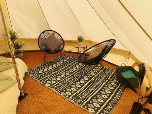 two chairs and a rug in a tent at Bluebell Wilds in Whitchurch
