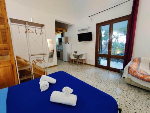 una camera da letto con un letto blu e asciugamani di Il Giardino su Lido Burrone a Favignana