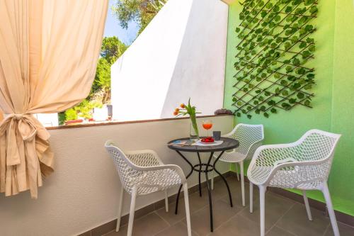 a balcony with a table and chairs and a window at Apartmani Nikola in Baška Voda