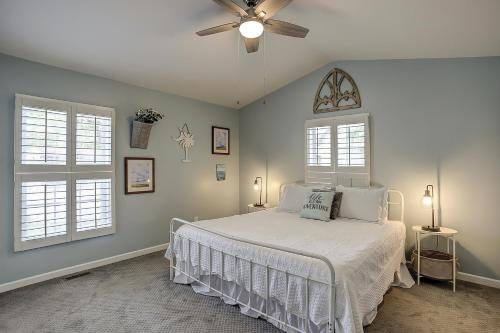 a bedroom with a bed with a ceiling fan and two windows at Pura Vida - A -Murrells Inlet in Myrtle Beach
