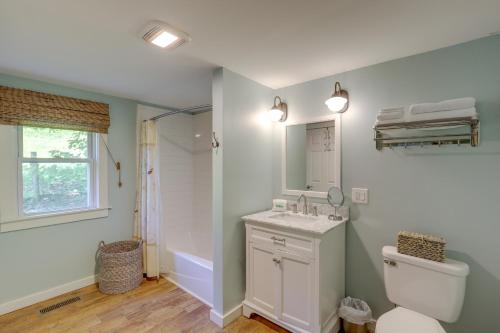 a bathroom with a toilet and a sink and a mirror at Secluded Marshall Cottage Hot Tub and Mountain View in Marshall