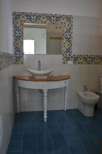 a bathroom with a sink and a toilet at B&B Talìa in Scopello