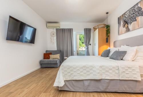 a bedroom with a bed and a flat screen tv at Apartmani Nikola in Baška Voda
