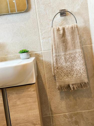 a towel hanging on a wall next to a sink at Honeycomb Designer Apartment in St Paul's Bay