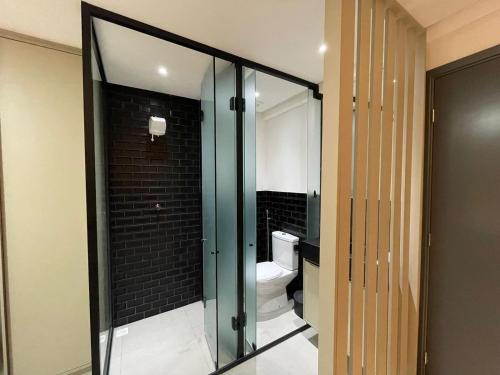 a bathroom with a toilet and a glass door at Get One - Bessa in Tambaú