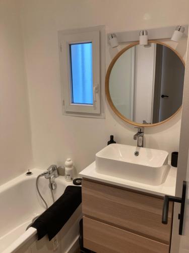 Un baño con lavabo, espejo y bañera. en OSoleMio Moliets, en Moliets-et-Maa
