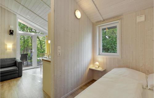 ein Schlafzimmer mit einem Bett, einem Stuhl und einem Fenster in der Unterkunft Schmugglerstieg 13d - Dorf 5 in Travemünde