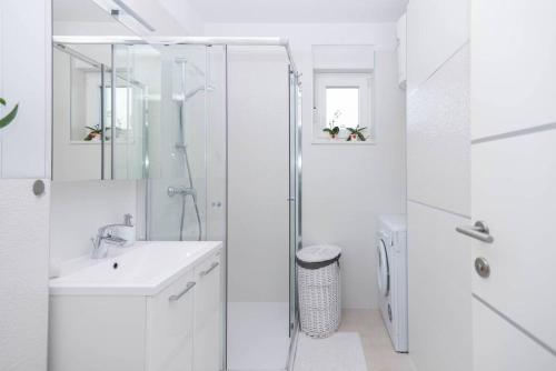 a white bathroom with a shower and a sink at Feel like Home in Podstrana