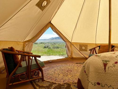 Tienda de campaña con cama y silla en una habitación en Sage Oasis Garden Retreat en Hot Springs