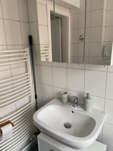 a white bathroom with a sink and a mirror at Silbertaler in Bad Harzburg