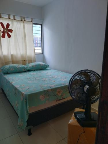 um quarto com uma cama, uma ventoinha e uma janela em Casa sol e mar pe na areia em Paulista
