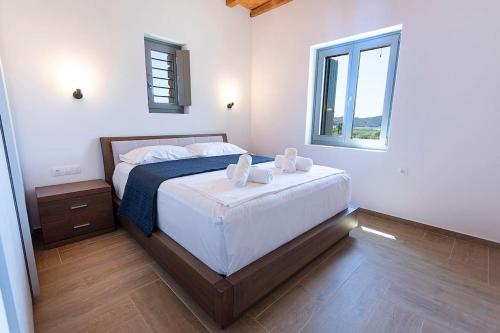 a bedroom with a bed with two towels on it at SeaeyeVillas 1 in Livadi