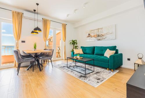 a living room with a green couch and a table at Apartmani Nikola in Baška Voda