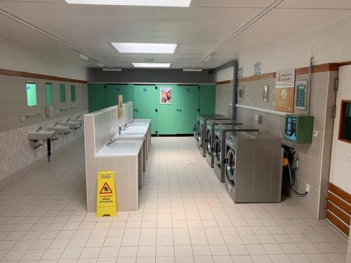 a laundry room with washing machines and sinks and toilets at L'échappée parisienne in Saint-Chéron