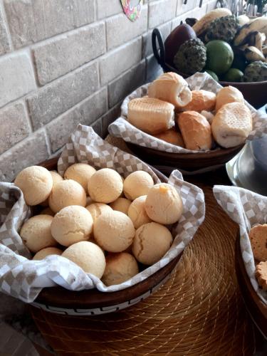three baskets of bread and rolls on a table at Casa Espetacular no Centro de Diamantina in Diamantina