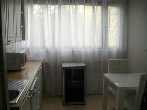 a kitchen with a window with white curtains at 21 minutes from Helsinki city - larger room in Kauniainen