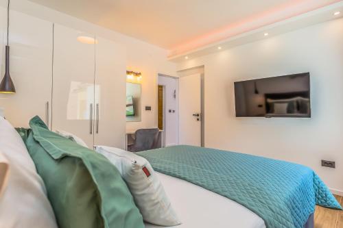 a bedroom with a bed with a tv on the wall at Apartmani Nikola in Baška Voda