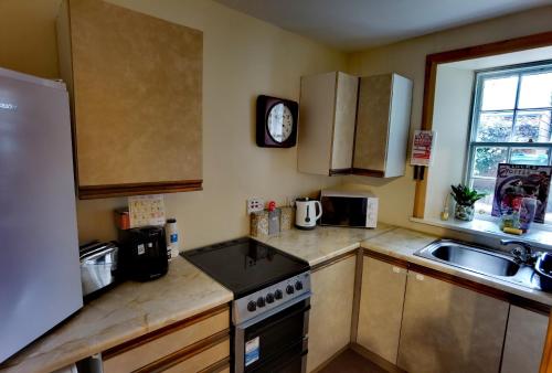 a kitchen with a sink and a stove top oven at Studio in the heart of Kirkwall in Orkney