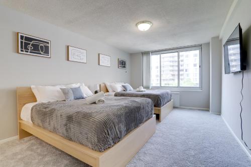 a bedroom with two beds and a television in it at Spectacular 2/2 Apt @Crystal City With Gym in Arlington