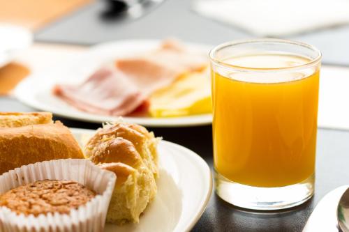 a plate of food and a glass of orange juice at Grand Bittar Hotel in Brasilia