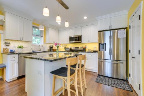 a kitchen with white cabinets and a stainless steel refrigerator at Freshly Renovated Raleigh Home Near Downtown! in Raleigh