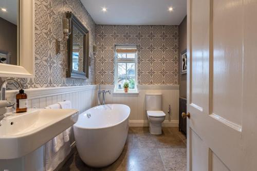 a white bathroom with a tub and a toilet at Luxury 17th Century townhouse/Central Norwich/Close to eateries/bars/shopping in Norwich