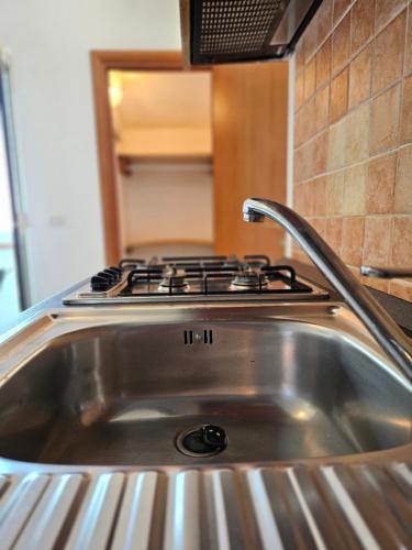 a stainless steel kitchen sink with a stove top at Tuppo delle pile Seaview in Peschici