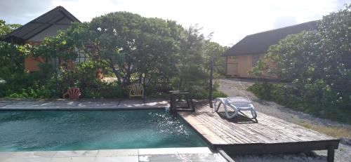 a swimming pool with a bench next to a house at FAKARAVA - Teariki Lodge 1 in Fakarava