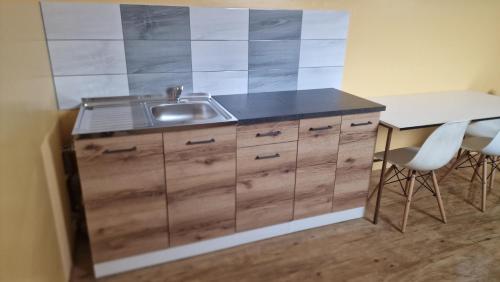 a kitchen with a sink and a counter with two chairs at Privat Prešov in Prešov