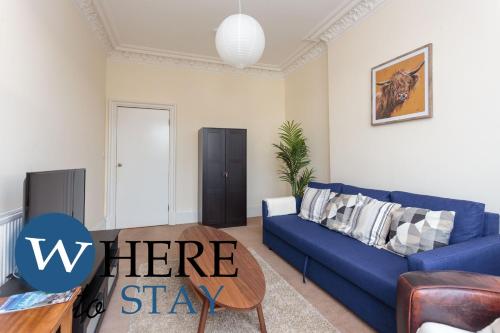 ein Wohnzimmer mit einem blauen Sofa und einem Tisch in der Unterkunft Delightful 2 bedroom apartment in Leith in Edinburgh