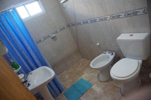 y baño con aseo blanco y lavamanos. en "AGUAPÉ" Alojamiento rural con PILETA en Chajarí