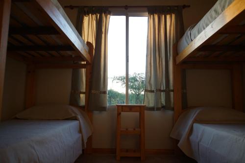 1 dormitorio con 2 literas y ventana en "AGUAPÉ" Alojamiento rural con PILETA en Chajarí