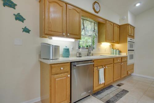 a kitchen with wooden cabinets and a stainless steel dishwasher at 2 Mi to Golf Retreat with Hot Tub in Ocean Pines in Ocean Pines