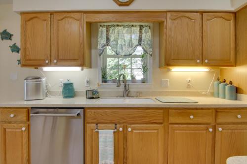 a kitchen with wooden cabinets and a sink and a window at 2 Mi to Golf Retreat with Hot Tub in Ocean Pines in Ocean Pines