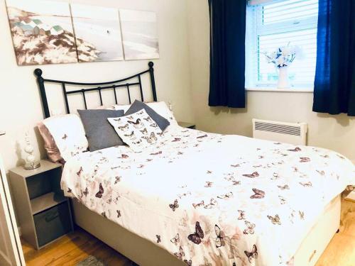 a bedroom with a bed with a comforter with butterflies at Turnstone in Seaton