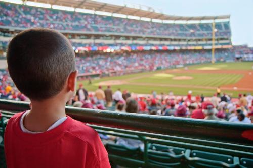 a young boy watching a baseball game at a stadium at Aloft Scottsdale in Scottsdale