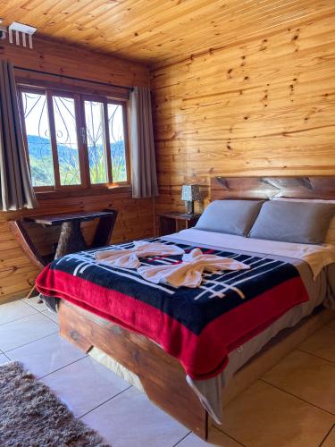 a bedroom with a bed in a wooden cabin at Pousada Recanto da Gruta in Urubici