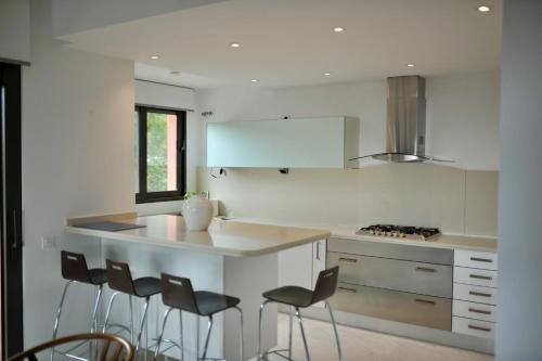 - une cuisine avec un comptoir et des tabourets dans l'établissement Bright apartment in the hills of Elviria, à Malaga