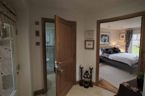 um quarto com uma cama e uma porta que leva a uma casa de banho em Loch Lomond Unique Selfcontained bed+bathroom em Alexandria