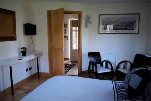 um quarto com uma cama, uma secretária e cadeiras em Loch Lomond Unique Selfcontained bed+bathroom em Alexandria